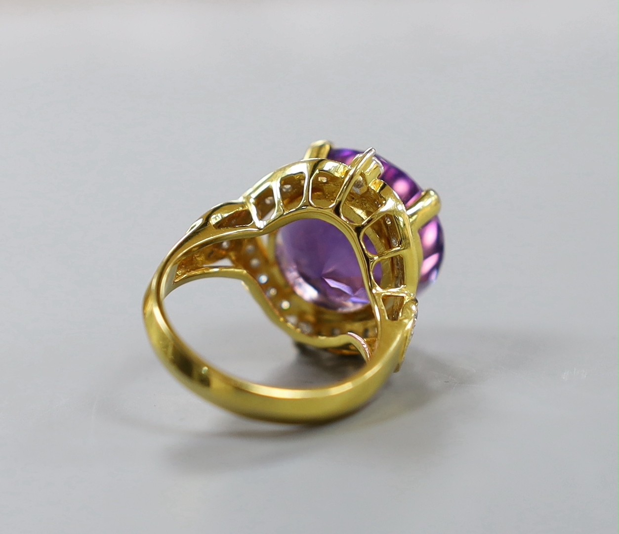 A modern yellow metal, round cut amethyst and diamond chip set cluster dress ring, size M, gross weight 10.9 grams.